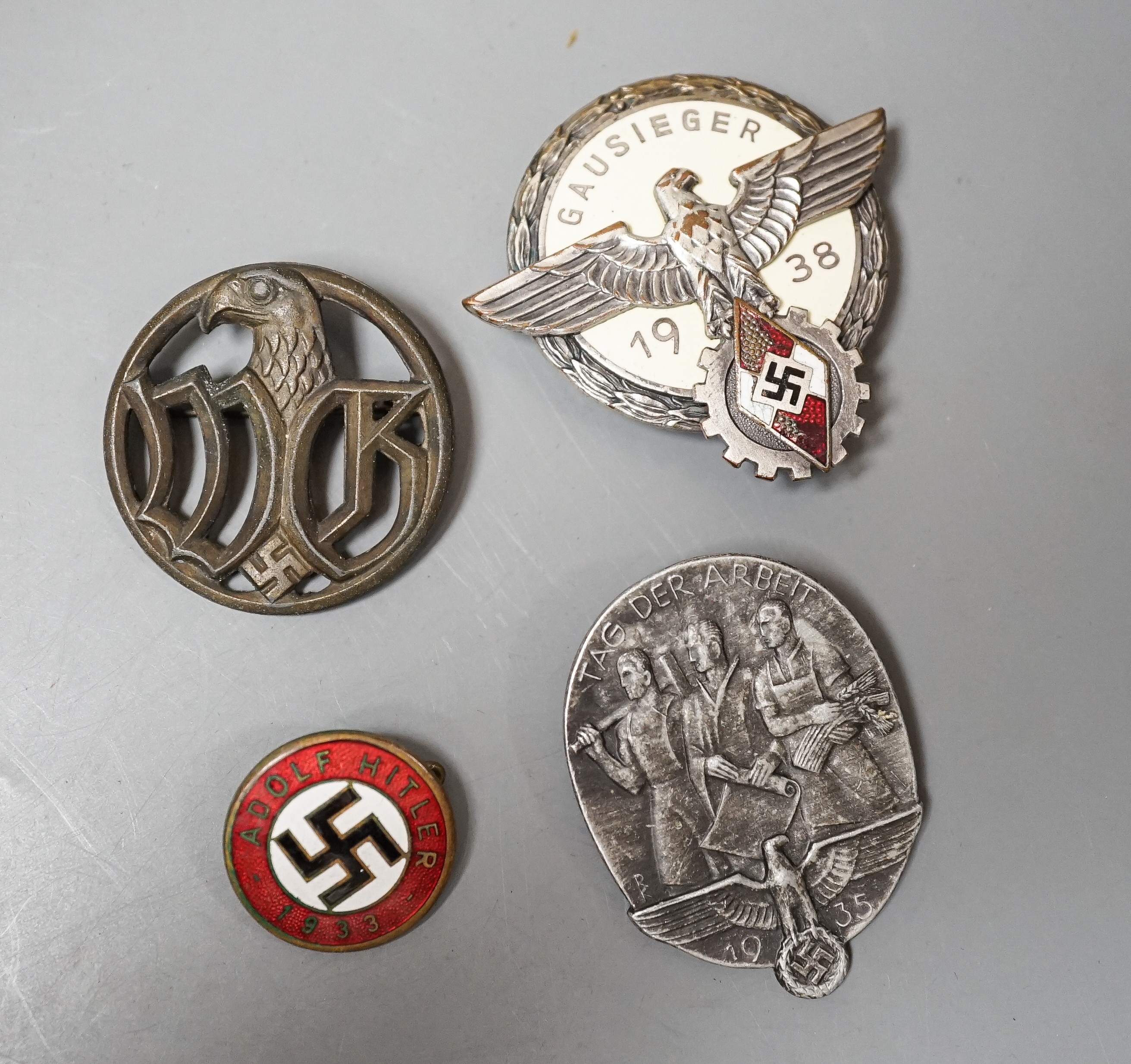 A WW2 German Hitler Youth Gausieger badge, a Wehrmachtgefolge badge for civilian workers, a Tag der Arbeit badge and an Adolf Hitler 1933 enamelled badge (4)